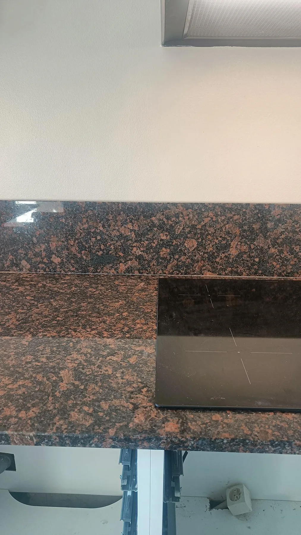 Detalj av polerad Tan Brown granit vid hällen med brun mineralteckning och matchande stänkkant i Malmö.