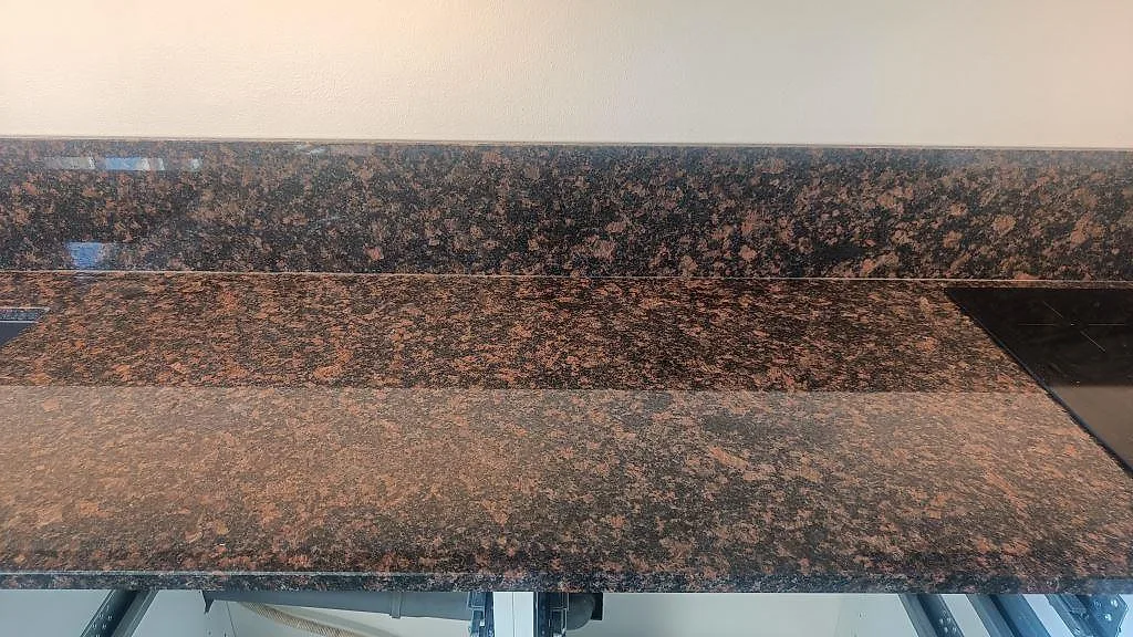 Arbetsyta i polerad Tan Brown granit med brun mönstring, stänkkant och synliga diskho- och hällzoner i Malmö.