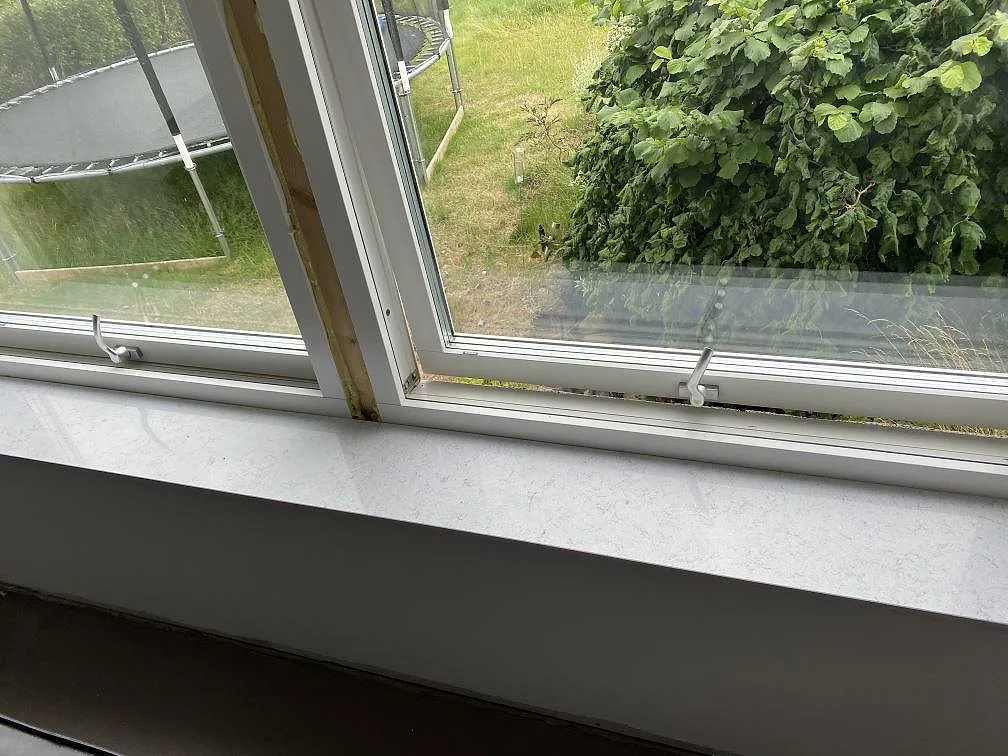 Fönsterbänk i Technistone Brilliant Arabesco, vit kvartskomposit med grå ådring, monterad i samma sten som köksbänkskivan i Vallberga.