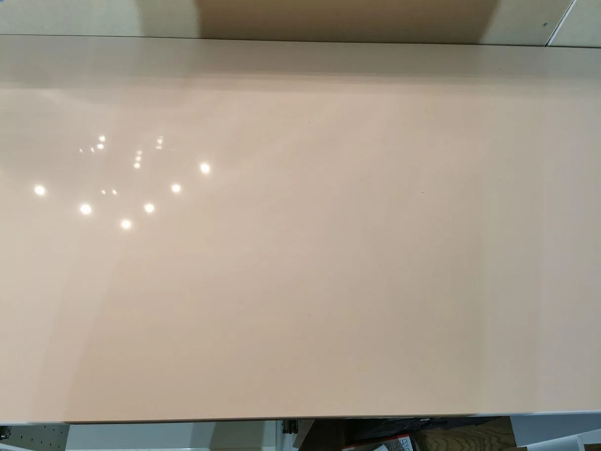 Polerad köksbänkskiva i vit Technistone Crystal Absolute White som speglar takets spotlights i ett kök i Båstad.