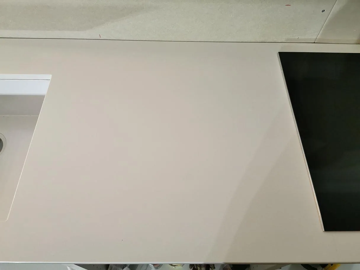 Polerad köksbänkskiva i Technistone Crystal Absolute White med diskhourtag och plats för induktionshäll i ett kök i Båstad.