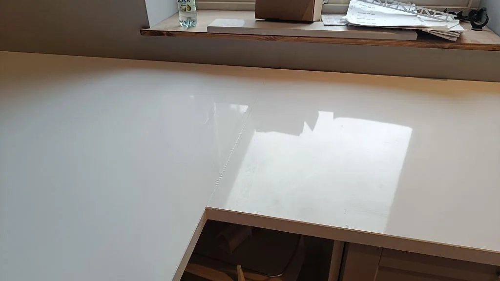 Blank vit yta i Technistone Crystal Absolute White, polerad komposit, vid fönsterbänken i köket i Fjälkinge.