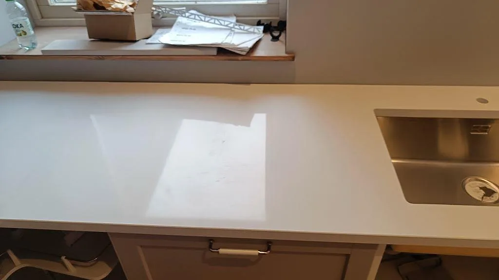 Diskzon med rostfri diskho och polerad vit Technistone Crystal Absolute White som köksbänkskiva under montering i Fjälkinge.