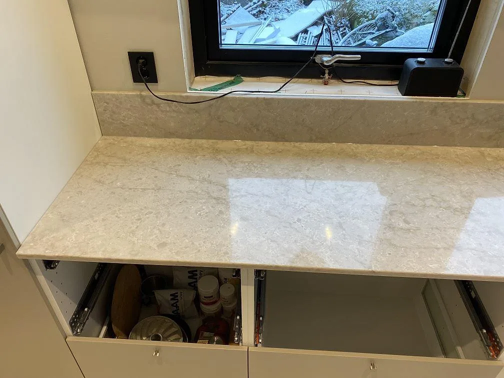 Rak bänkyta i polerad Technistone Glencoe med ljus ådring och uppvikt stänkkant i Alafors.