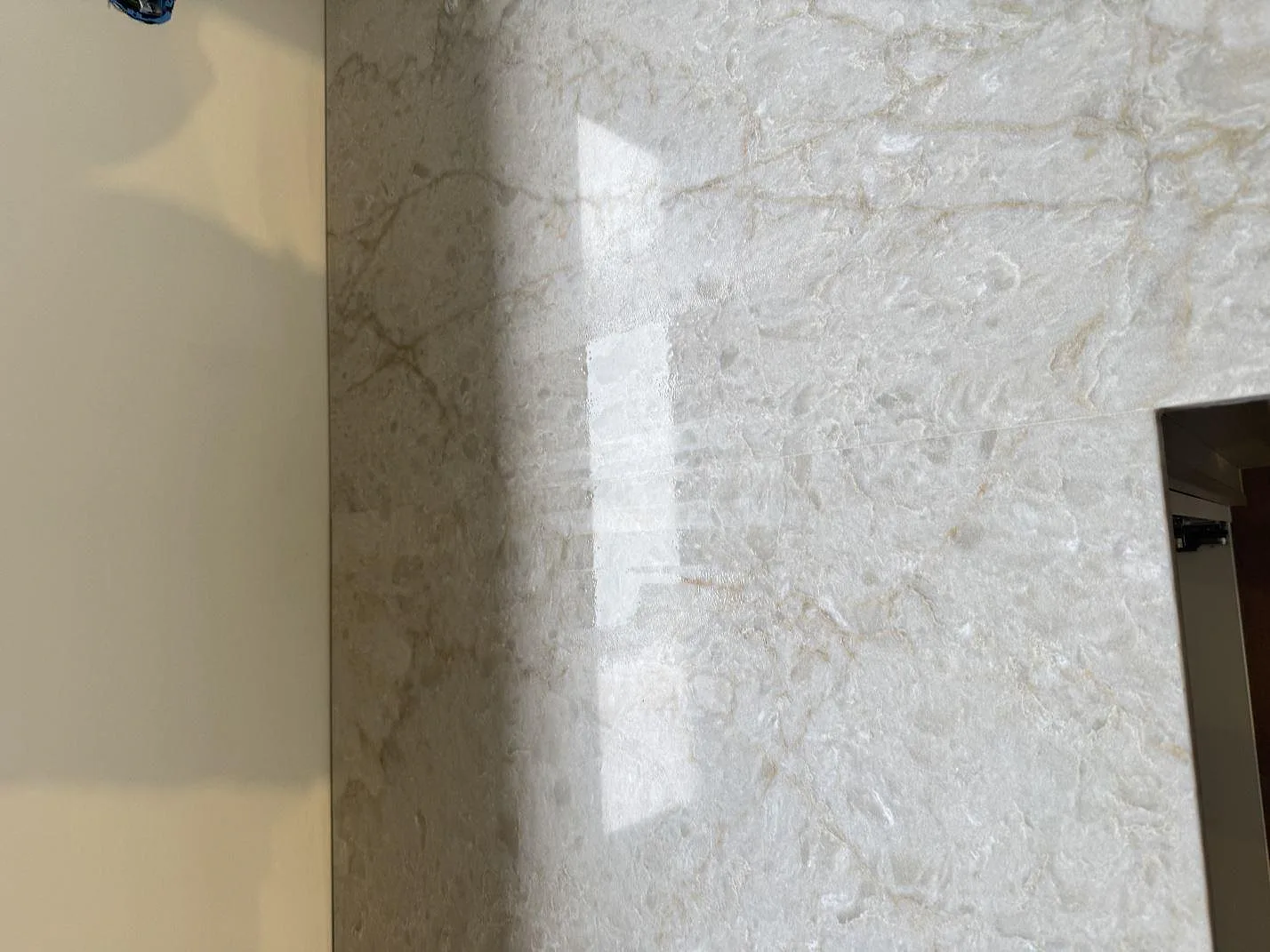 Topvy av polerad Technistone Glencoe köksbänkskiva med ljus kompositådring och fönsterreflexer i Birkerød.