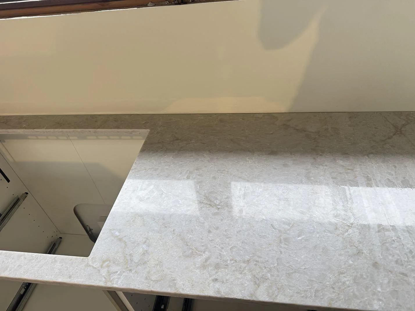 Polerad Technistone Glencoe bänkskiva med stor öppning och blank ljus komposityta under montering i Birkerød.