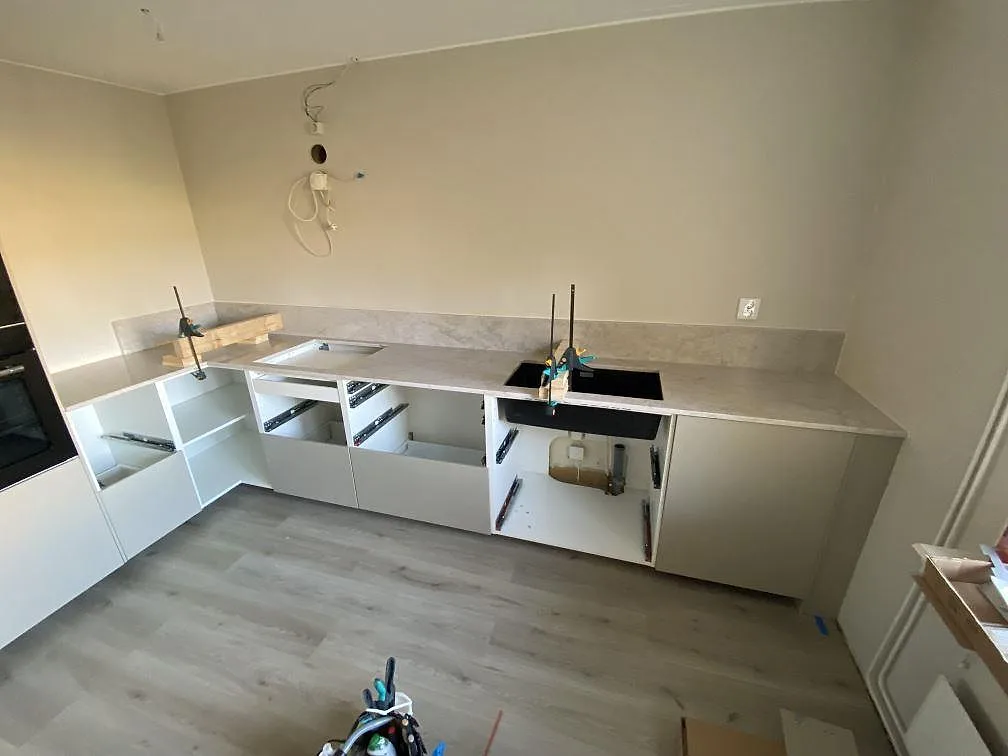 Köksbänkskiva i Technistone Glencoe komposit, 20 mm polerad, med stänkskydd i ett kök under montering i Malmö.
