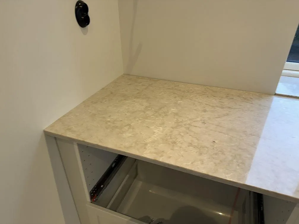 Sidovy av installerad köksbänkskiva i polerad Technistone Glencoe på öppna köksstommar i Skegrie.