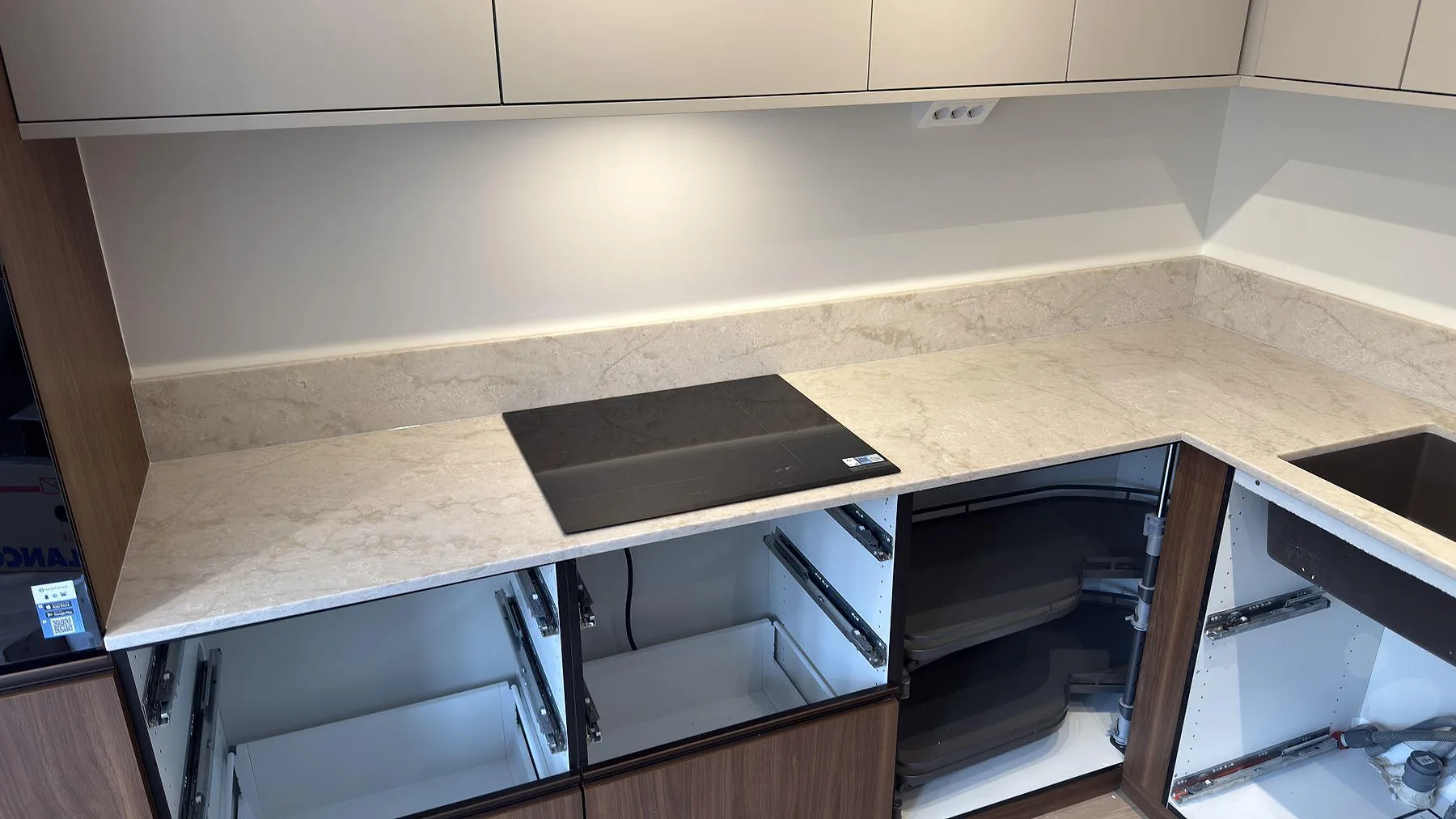 Polerad bänkskiva i Technistone Glencoe med tydlig grå ådring och uppvikt stänkkant i samma sten i ett kök i Stockholm.