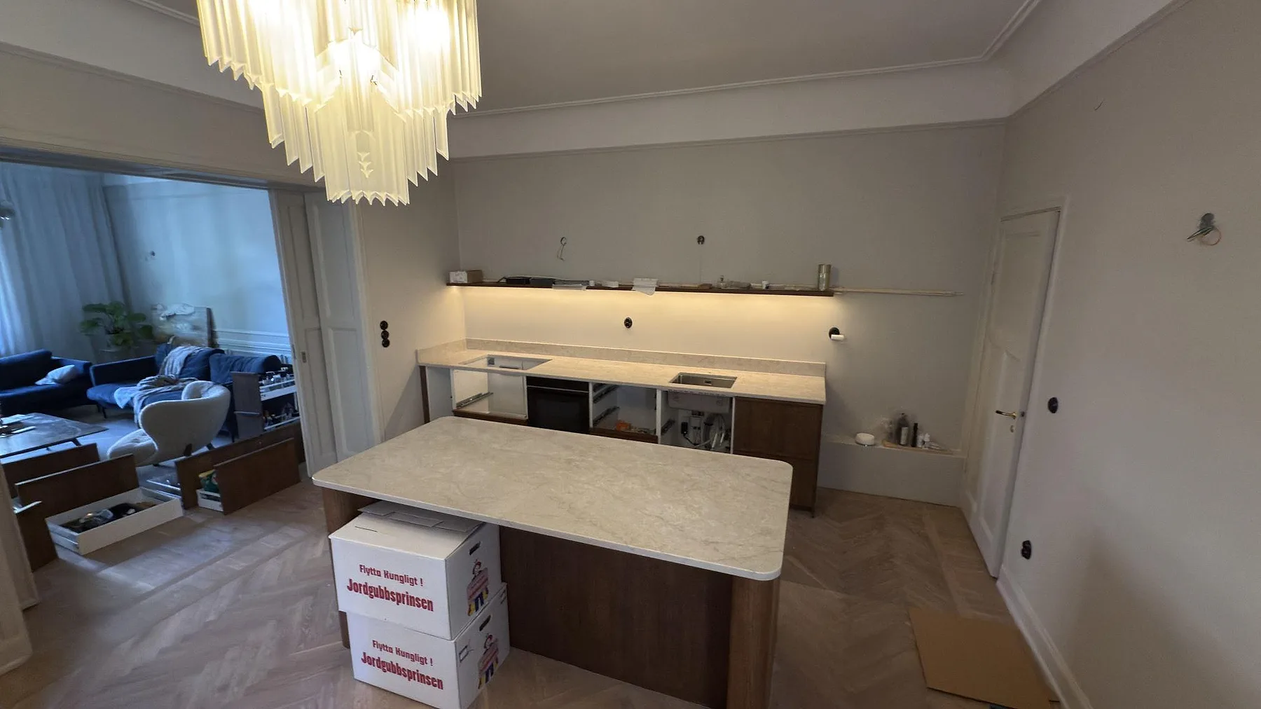 Kök i Stockholm med köksö och bänk i ljus Technistone Glencoe kvartskomposit, fotograferat under montering.
