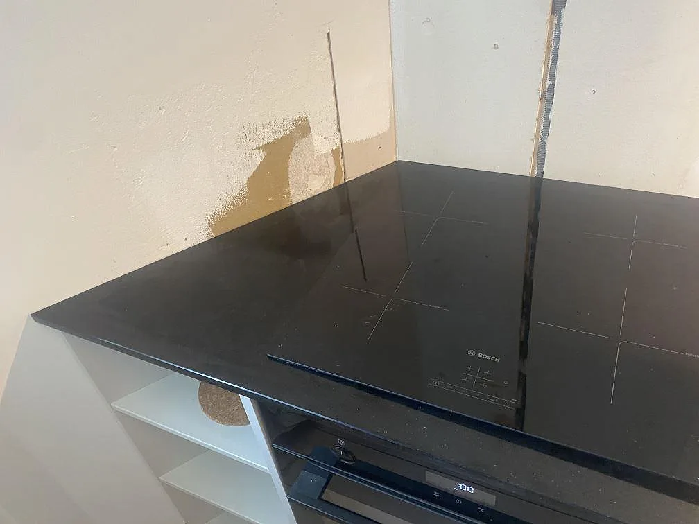 Detalj av infälld Bosch induktionshäll i svart Technistone Gobi Black köksbänkskiva i ett kök i Göteborg.