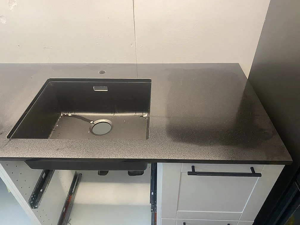 Stor underlimmad diskho i svart Technistone Gobi Black köksbänkskiva, polerad yta, i ett kök i Göteborg.