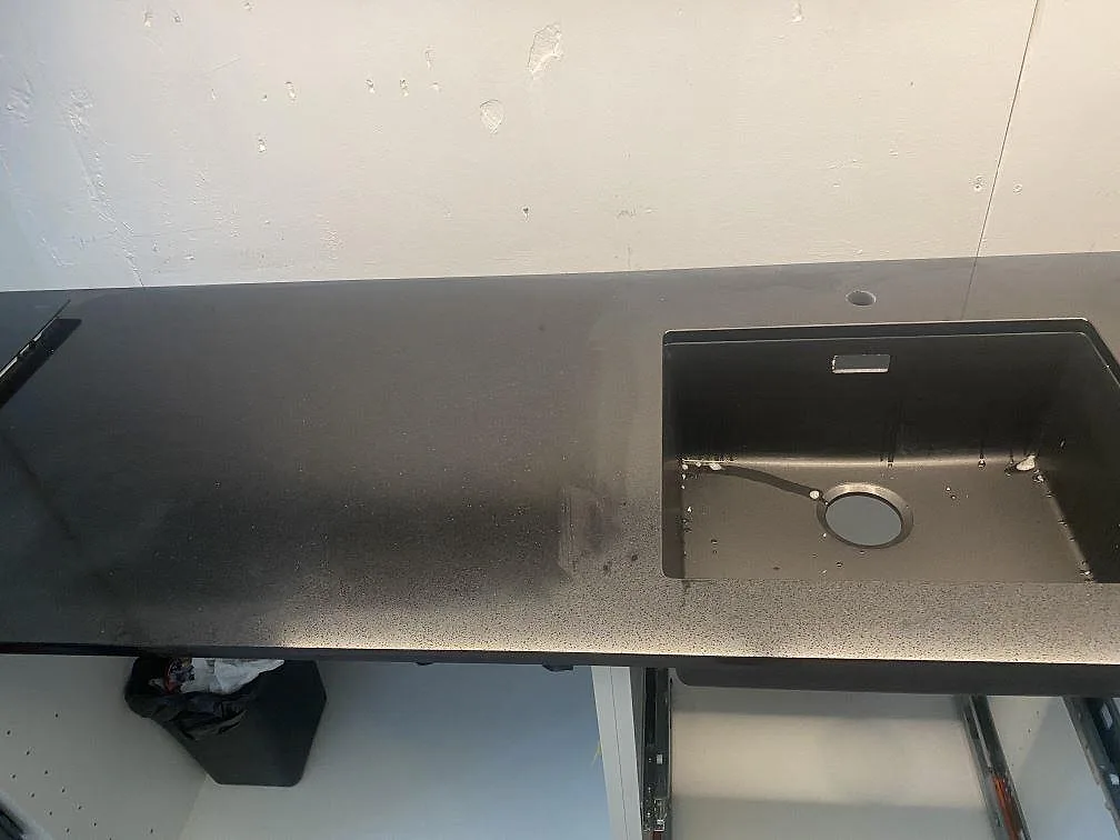 Lång svart köksbänkskiva i Technistone Gobi Black sedd ovanifrån med stor underlimmad diskho i ett kök i Göteborg.