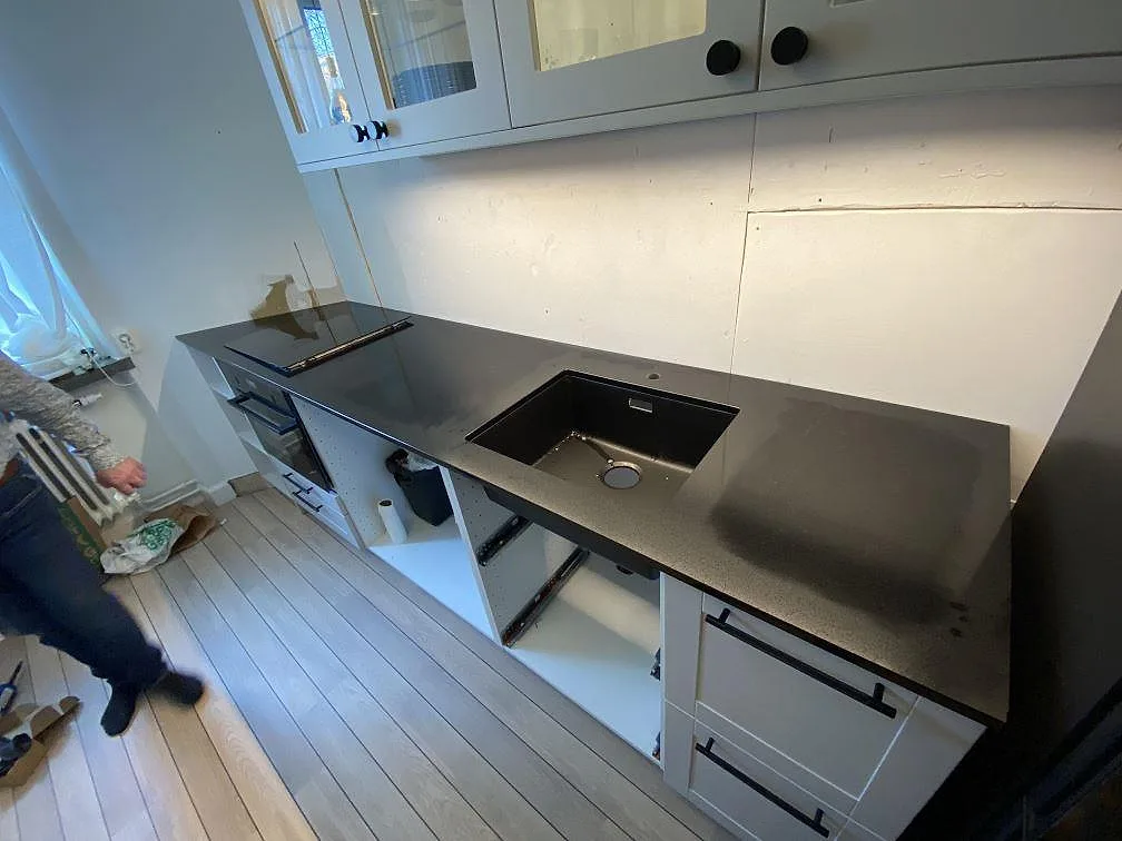Köksbänkskiva i svart Technistone Gobi Black, polerad, med underlimmad diskho och infälld induktionshäll i ett kök i Göteborg.