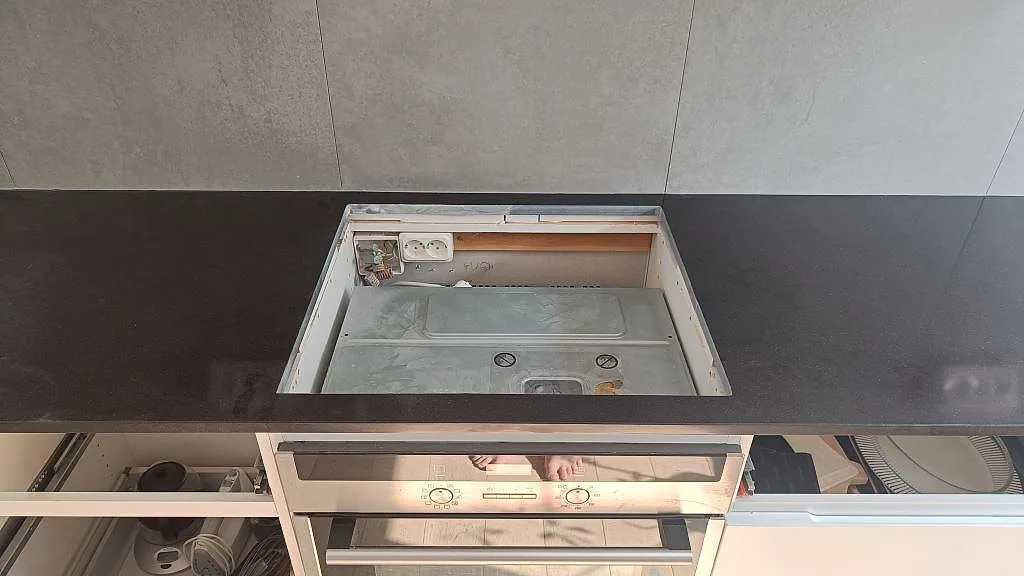 Detalj av hällurtag i polerad Technistone Gobi Black köksbänkskiva ovanför ugnen i Göteborg.