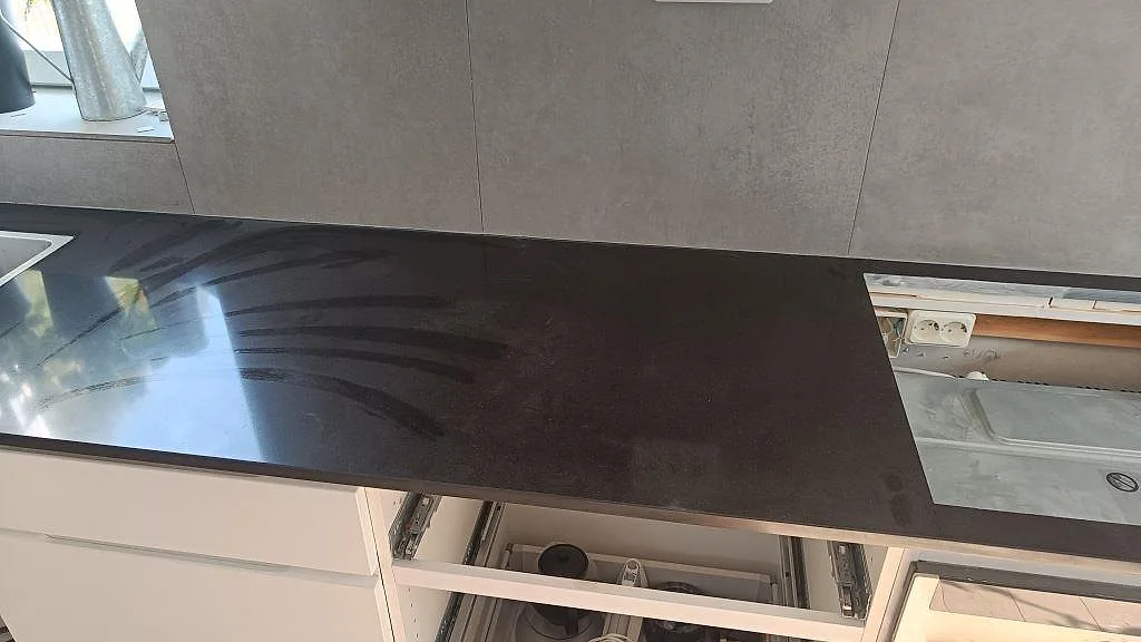 Lång köksbänkskiva i Technistone Gobi Black, polerad svart kvartskomposit, med diskho och hällurtag i Göteborg.