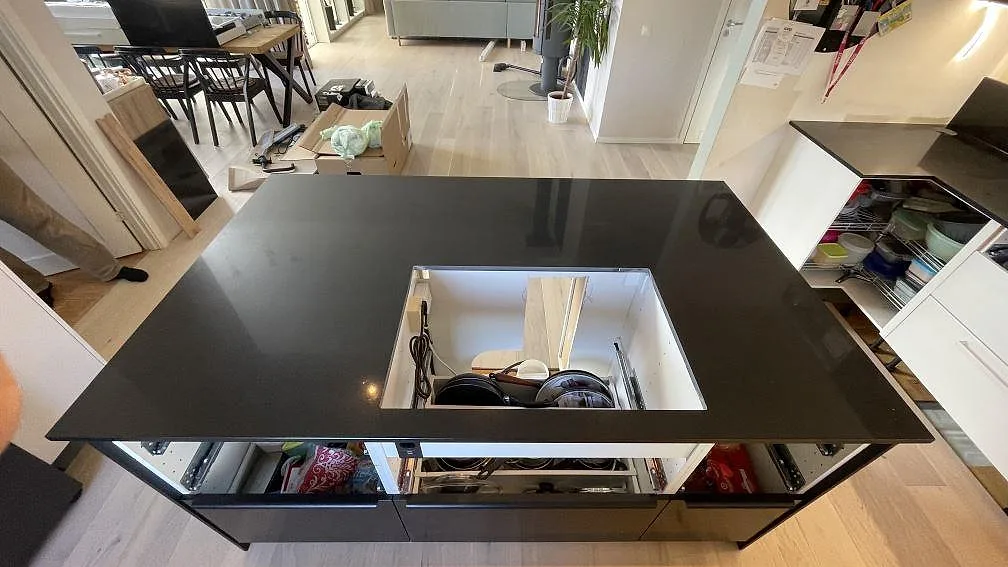 Polerad köksö i Technistone Gobi Black med större urtag i den svarta kompositskivan under montering i Kalmar.