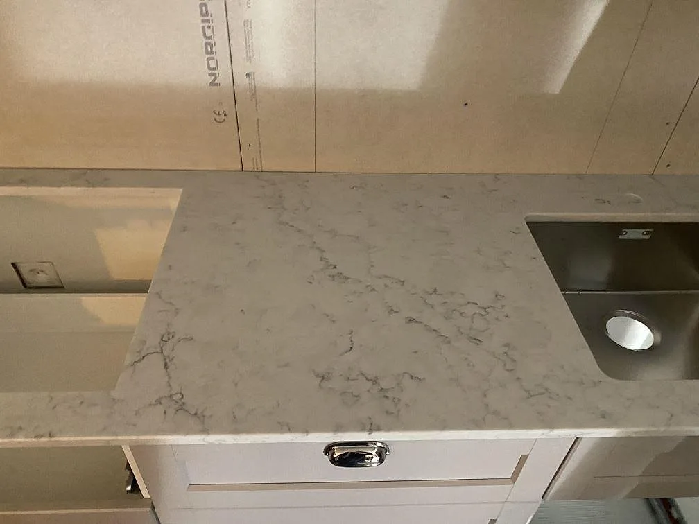 Vit Technistone Mystery White bänkskiva med underlimmad rostfri diskho och cup pull lådfront i ett kök i Alingsås.
