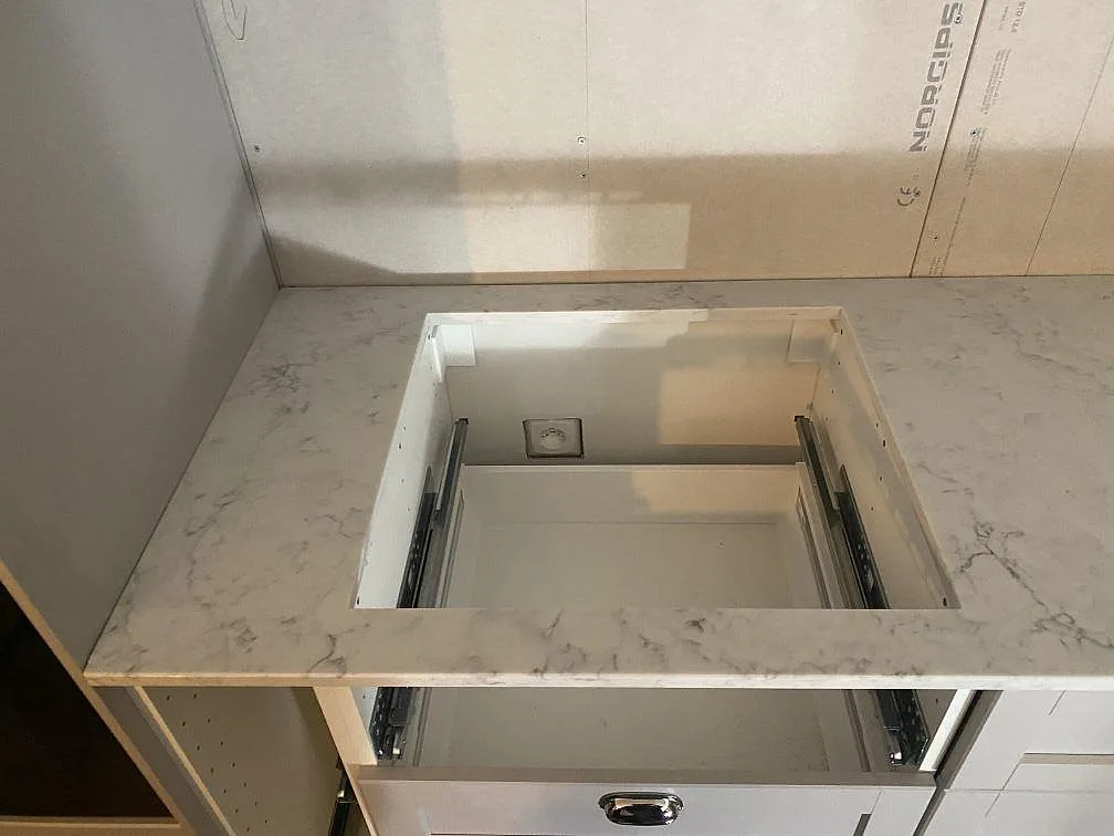 Vit komposit bänkskiva i Technistone Mystery White med urtag för låda i ett kök i Alingsås.