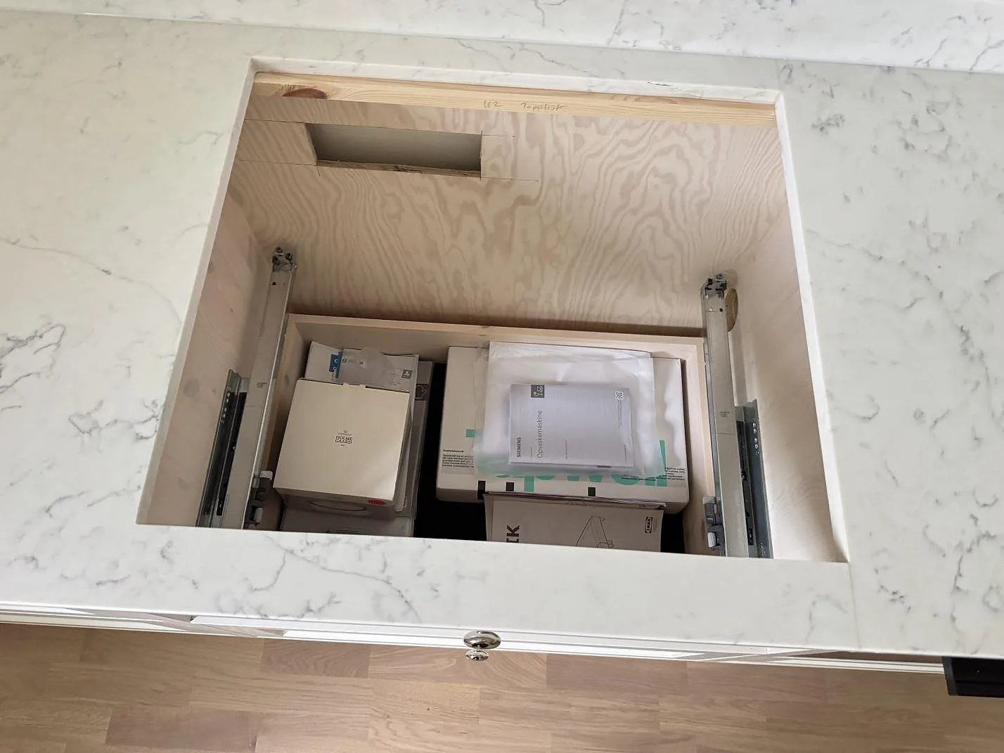 Ovanvy av rektangulärt urtag i polerad Technistone Mystery White köksbänkskiva med marmorerad grå ådring i Barsebäck.
