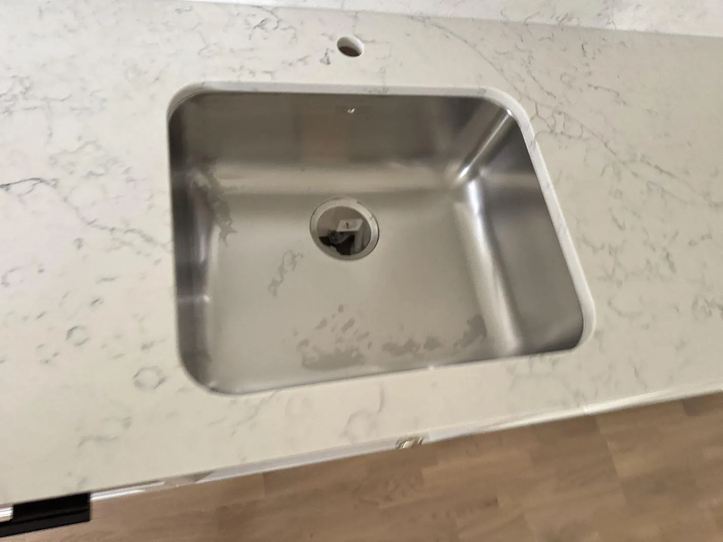 Rostfri diskho i polerad Technistone Mystery White köksbänkskiva med blandarhål och ljus kompositsten i Barsebäck.