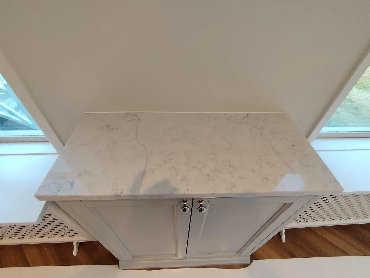 Sidobänk vid fönster i polerad Technistone Mystery White med synlig ljusgrå ådring i Bromma.