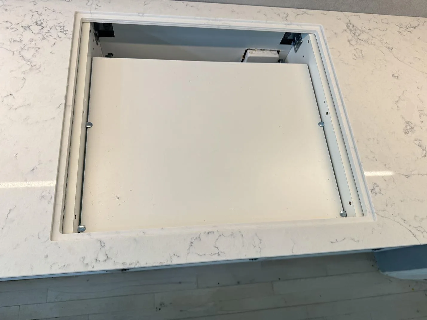Rektangulär öppning i polerad Technistone Mystery White köksbänkskiva med grå ådring, fotograferad under montering i Charlottenlund.