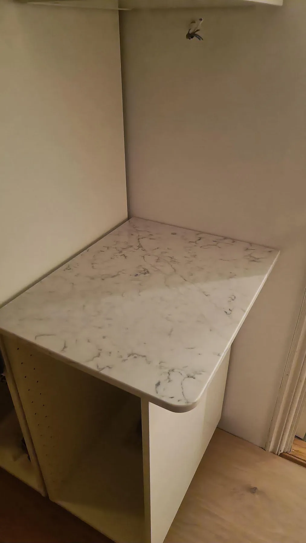 Sidobänk i polerad Technistone Mystery White med rundad framkant på öppen stomme i Falsterbo.