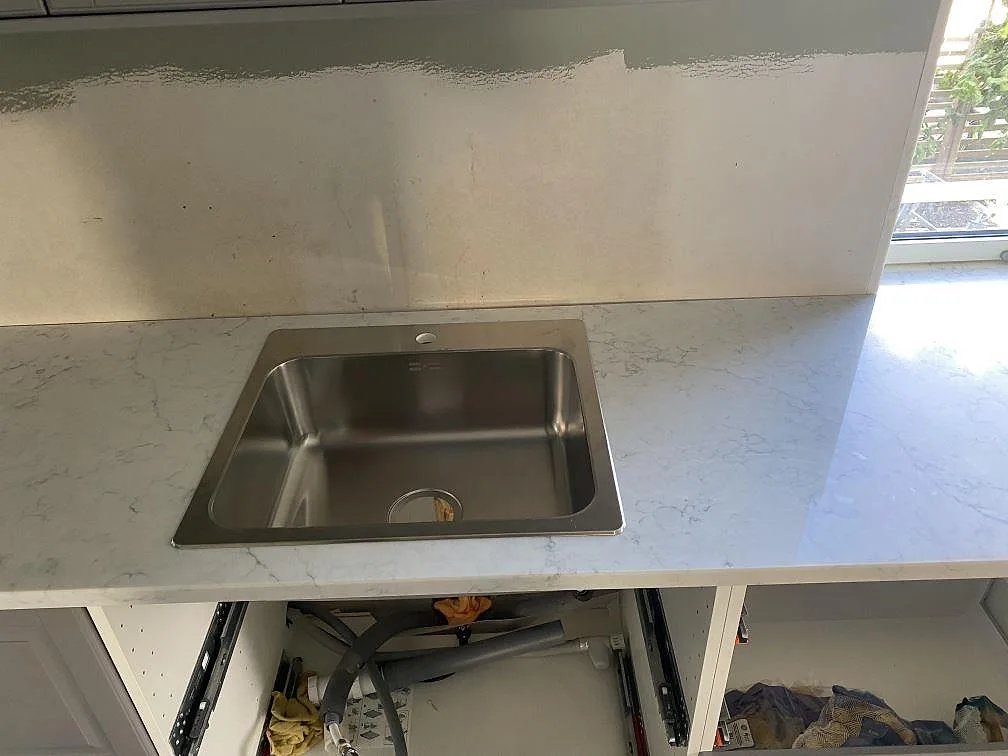 Närbild på den polerade ytan i Technistone Mystery White köksbänkskiva med fin grå ådring i ett kök i Klagstorp.