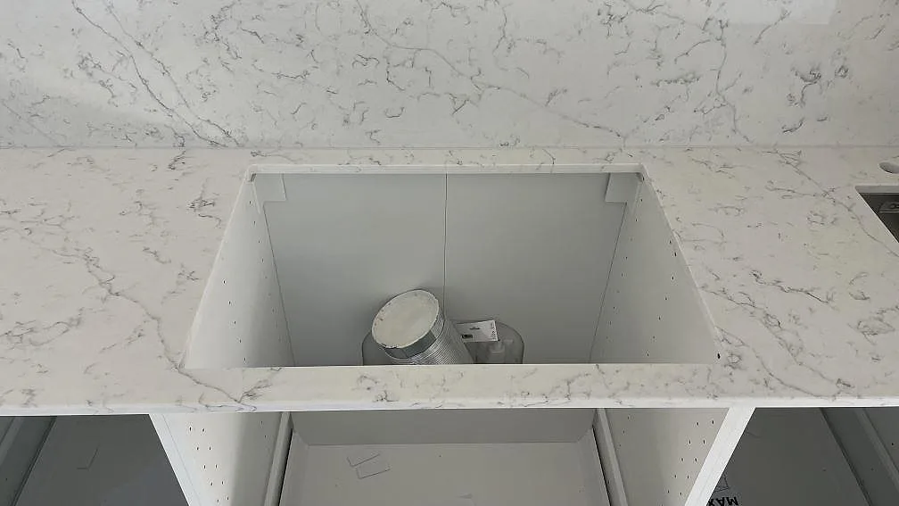 Närbild på hällöppning i polerad Technistone Mystery White komposit med samma sten som stänkskydd i Lomma.
