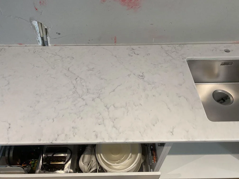 Vit köksbänkskiva i Technistone Mystery White komposit ovanifrån med underlimmad rostfri diskho och tydlig grå ådring i Lund.