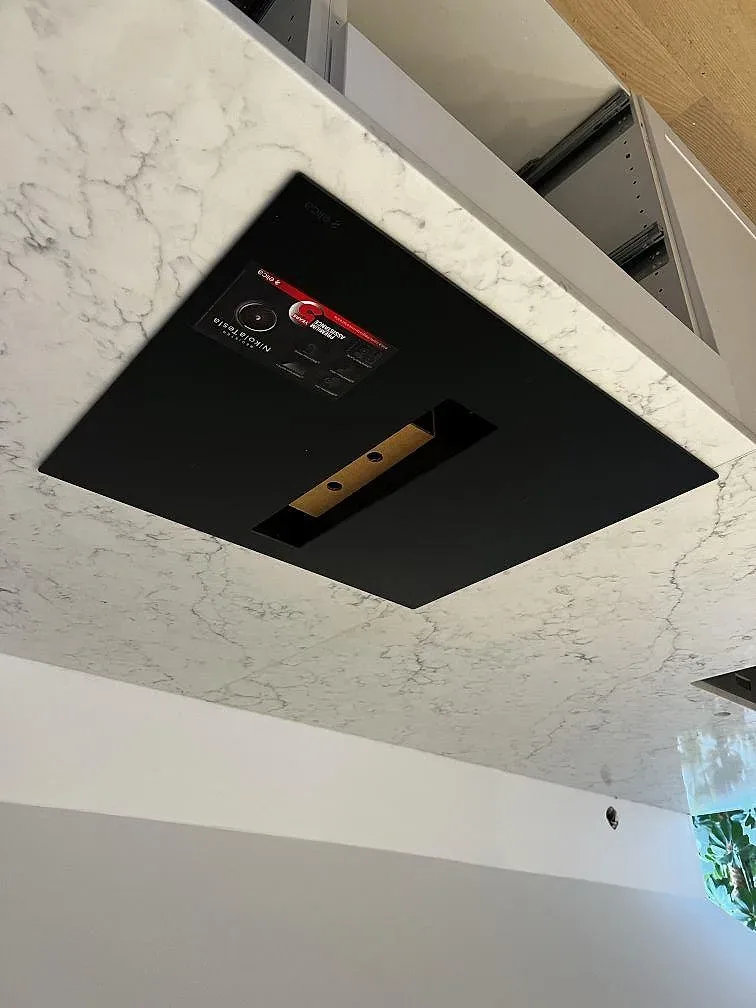 Köksö i vit Technistone Mystery White med infälld induktionshäll, polerad kvartskomposit i ett kök i Malmö.
