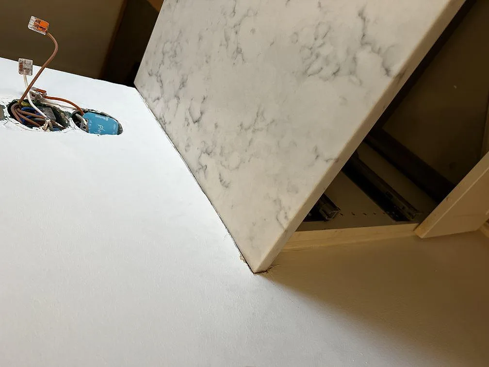 Kant på köksbänkskiva i 20 mm vit Technistone Mystery White, polerad kvartskomposit, i ett kök i Malmö.