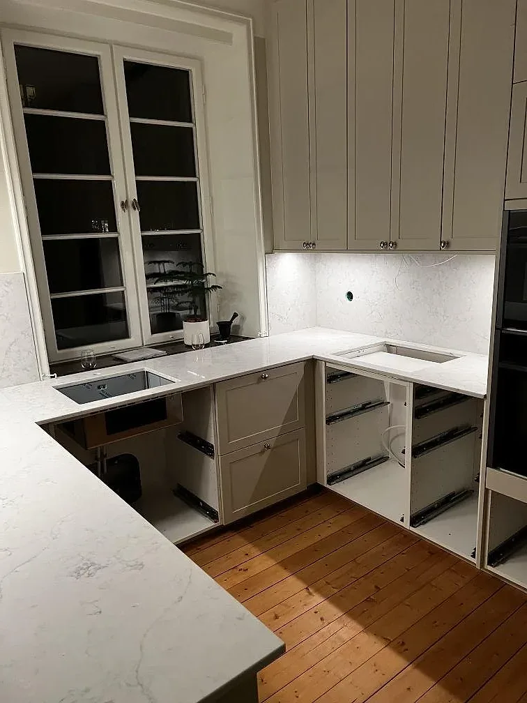 Polerad köksbänkskiva i Technistone Mystery White med ljus ådring, sedd över arbetsytorna i ett kök med trägolv i Malmö.