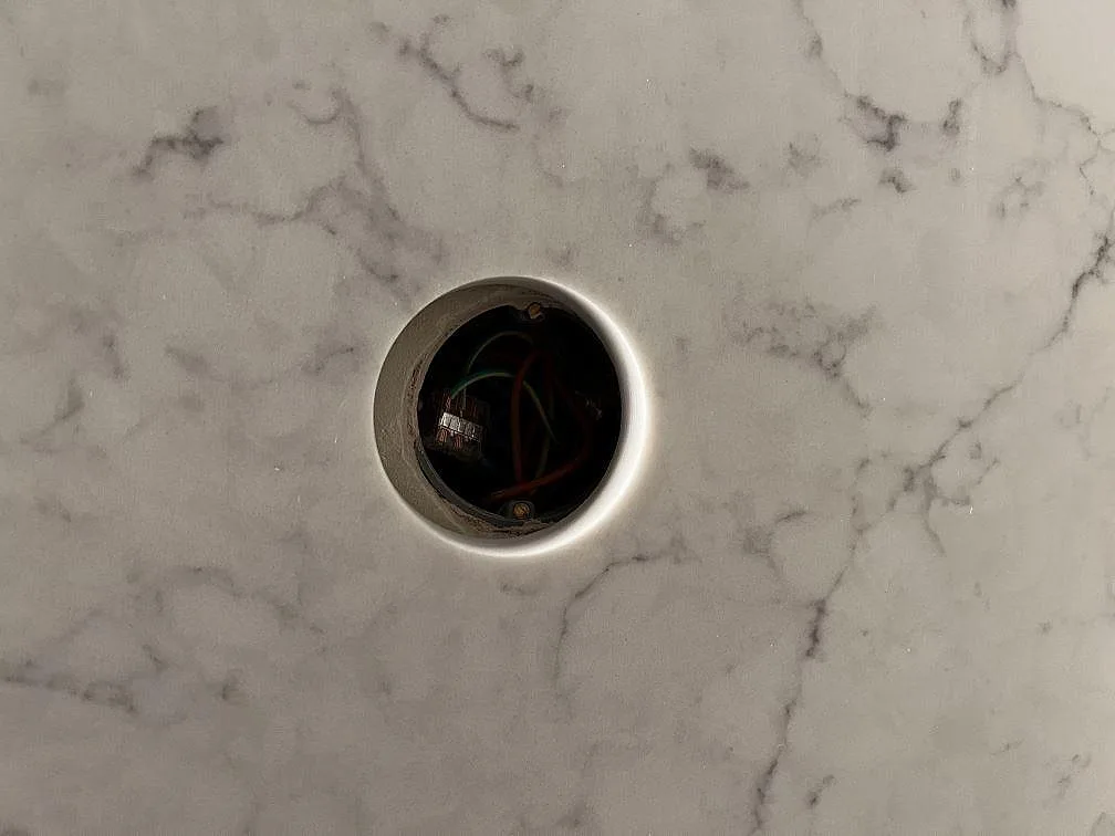 Tajt ytdetalj av polerad Technistone Mystery White komposit med rund genomföring och marmorerad ådring i Malmö.