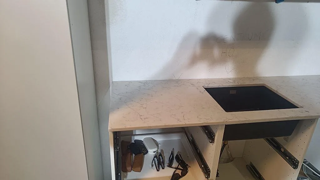 Vänster del av köksbänkskiva i Technistone Mystery White, polerad, fotograferad under montering i Malmö.