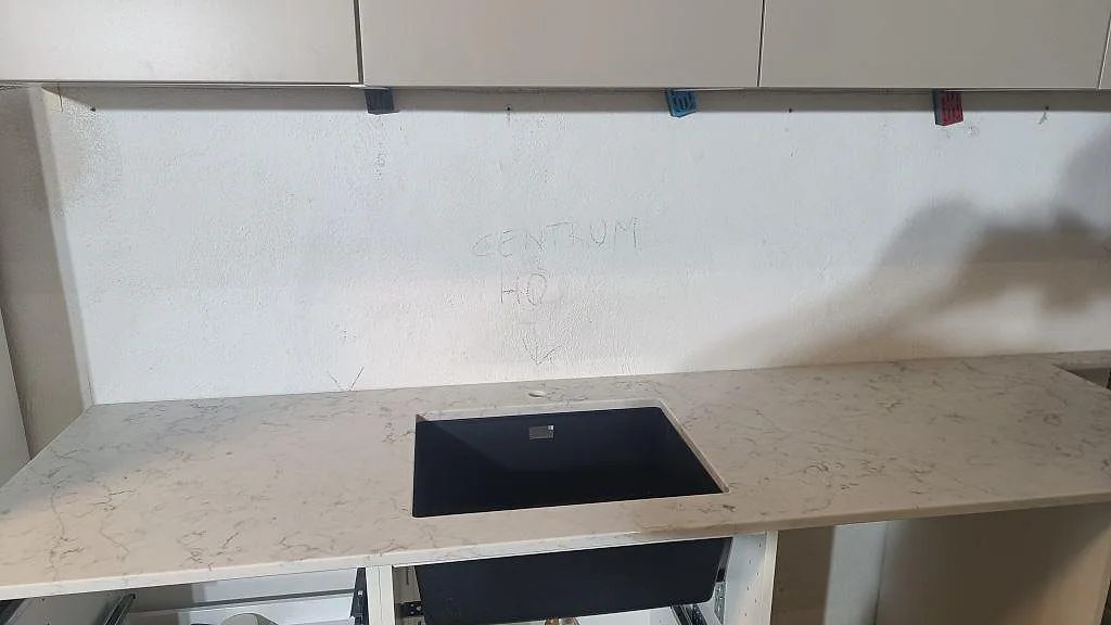 Polerad köksbänkskiva i Technistone Mystery White med grå ådring och öppning i arbetsytan i ett kök i Malmö.