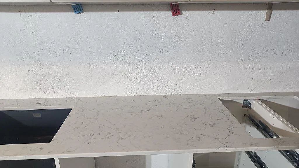 Närbild av polerad Technistone Mystery White i kök i Malmö, med ljus arbetsyta och synliga öppningar i bänkskivan.