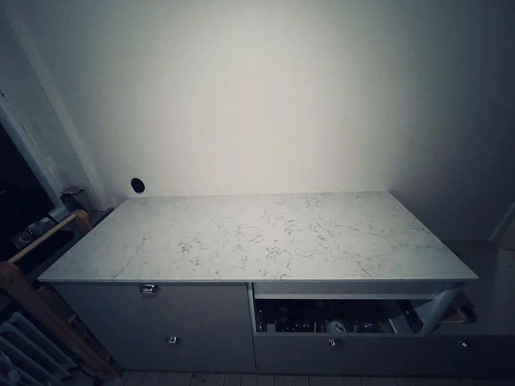 Närbild på den grå marmorlika ådringen i polerad Technistone Mystery White köksbänkskiva i Malmö.