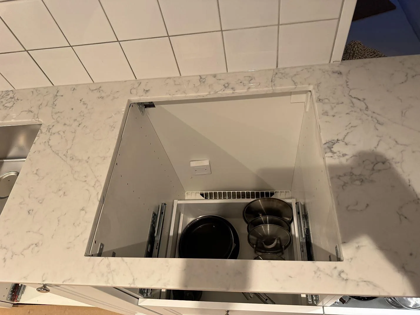 Hällöppning i polerad köksbänkskiva av Technistone Mystery White med grå ådring i ett kök under montering i Nyehusen.