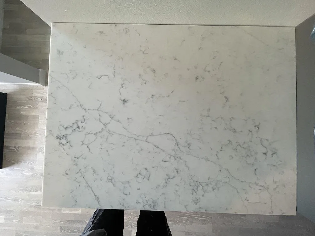 Närbild på den polerade Technistone Mystery White-bänkskivan med mjuk grå ådring på en köksdel i ett kök i Täby.