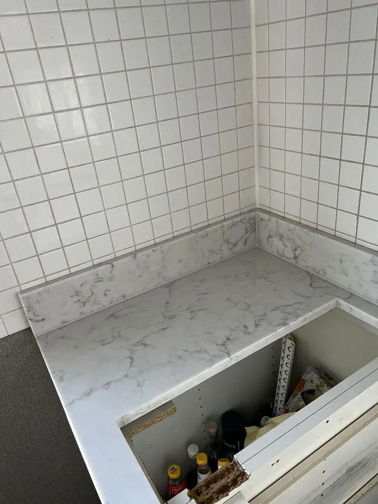 Hörn och uppvikt kant i Technistone Mystery White komposit mot vitt kakel i ett kök i Uddevalla.