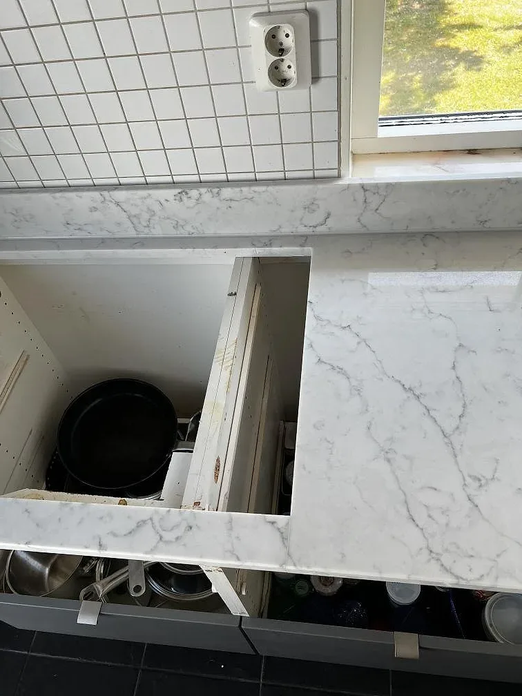 Detalj av monterad Technistone Mystery White komposit vid öppen köksstomme och vitt kakel i Uddevalla.