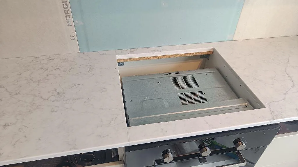 Hällöppning i köksbänkskiva av polerad Technistone Mystery White komposit under montering i Västra Frölunda.