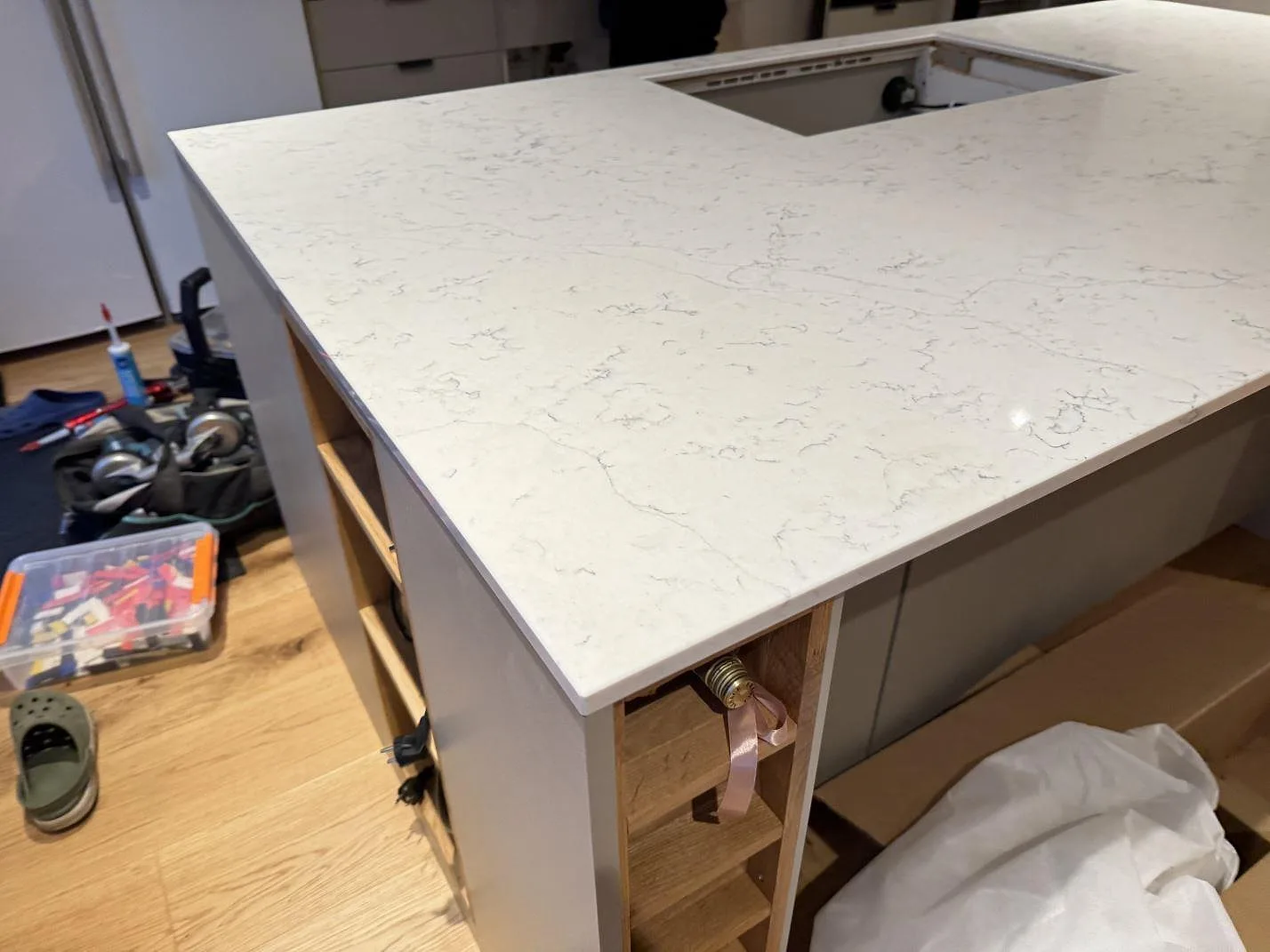 Köksö under montering med polerad Technistone Mystery White, hällöppning och verktyg vid sidan i ett kök i Veberöd.