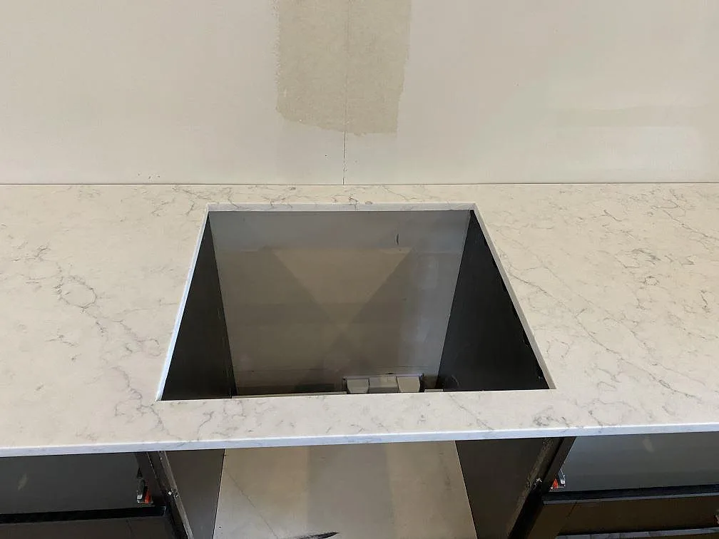 Köksbänkskiva i vit Technistone Mystery White med urtag för infälld häll i ett kök i Ystad.