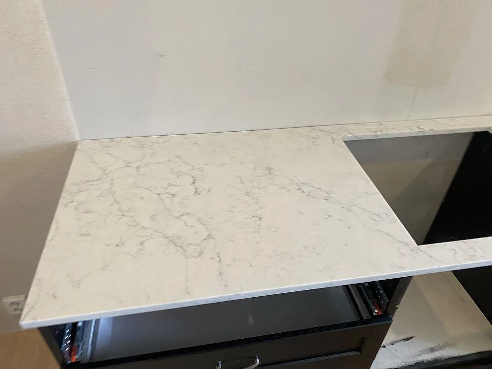 Polerad bänkskiva i vit Technistone Mystery White med diskret ådring i ett kök i Ystad.