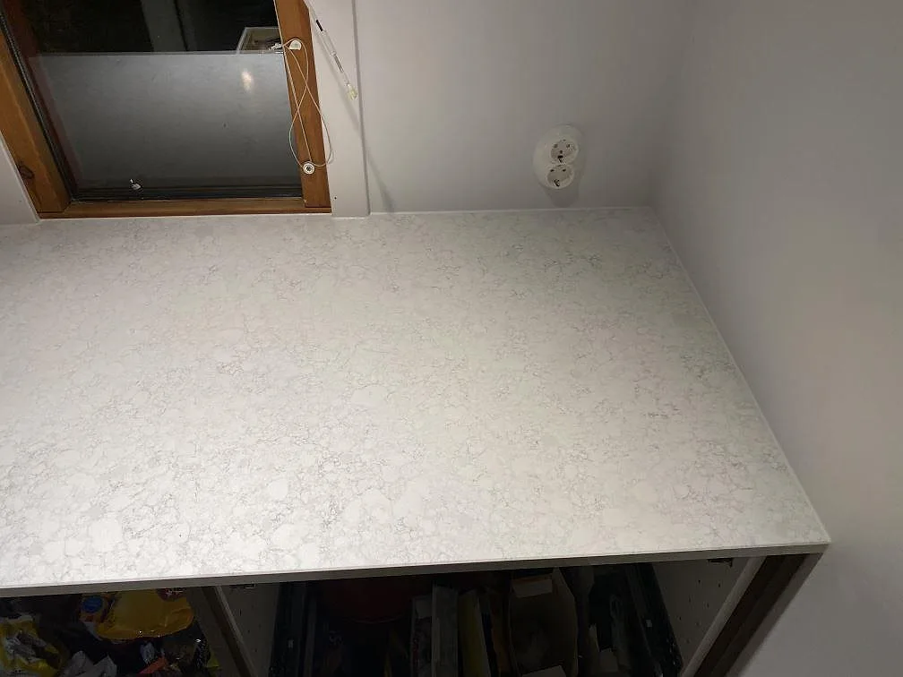 Hörndel av köksbänkskiva i Technistone Noble Arco komposit med stänkkant och polerad yta i Malmö.