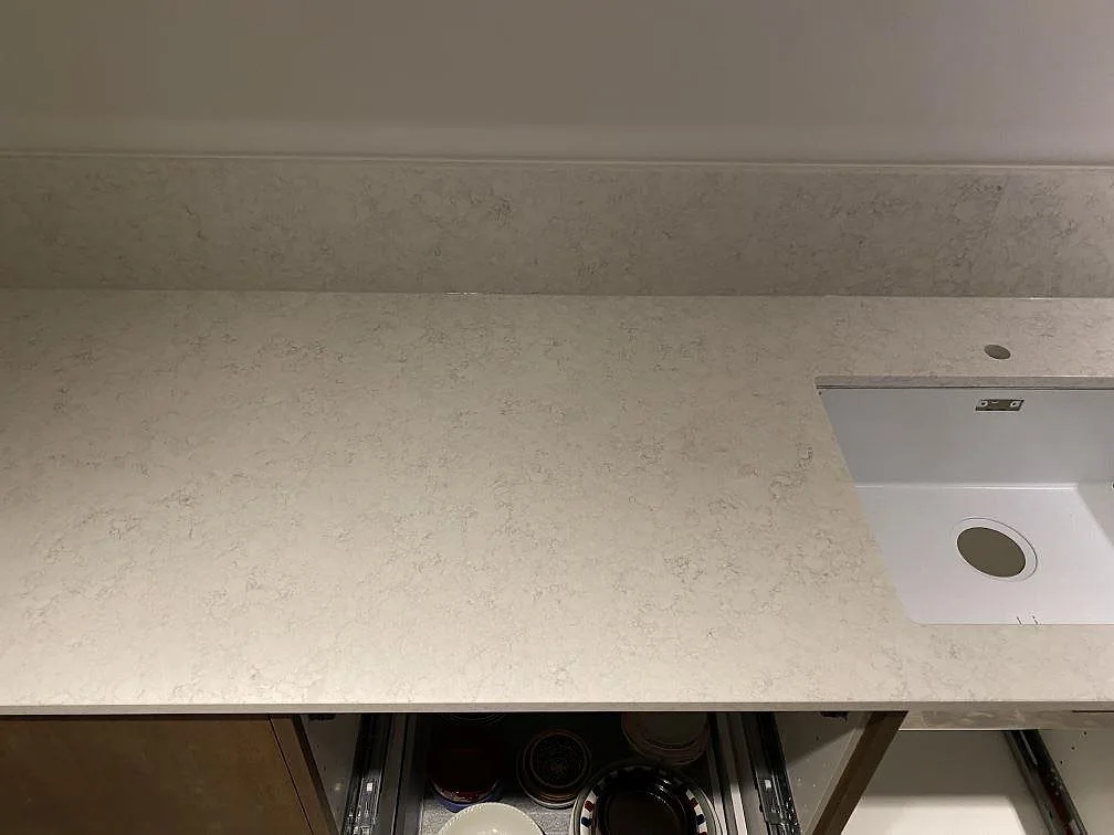 Technistone Noble Arco komposit, polerad, med synlig diskho och låg stänkkant längs väggen i Malmö.
