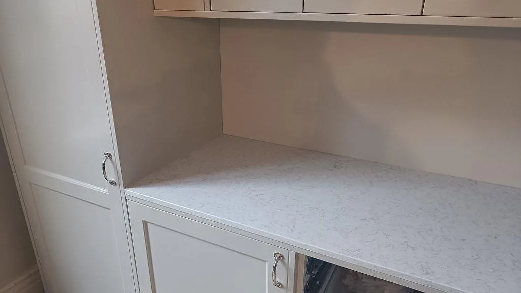 Separat köksbänk under överskåp i Technistone Noble Arco, polerad kvartskomposit med mjuk grå ådring i Malmö.